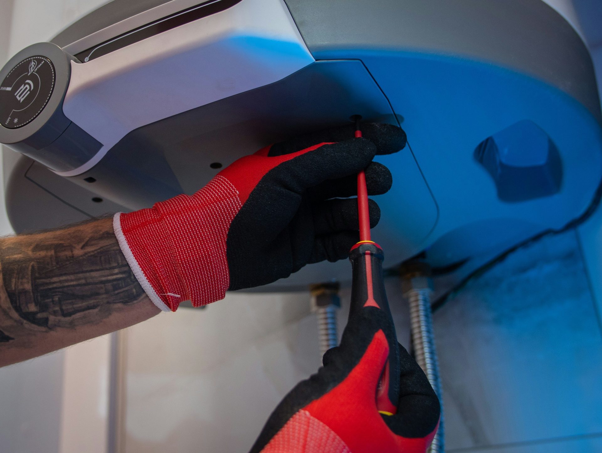 a man in red gloves working on a machine