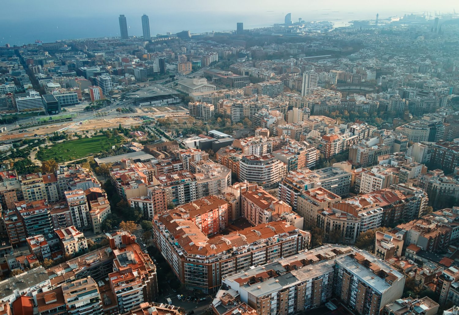 Aerial drone view of Barcelona, Spain. Blocks with multiple residential buildings, Mediterranean sea in the distance